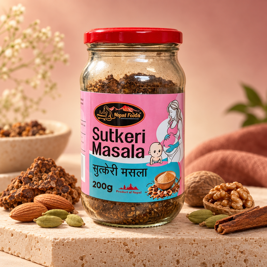A glass jar of Nepal foods Sutkeri Masala (sugar paste) with a pink and blue label and a red lid, styled on a stone surface with almonds, cardamom, walnut, cinnamon, and a bowl of ingredients against a warm pink background.
