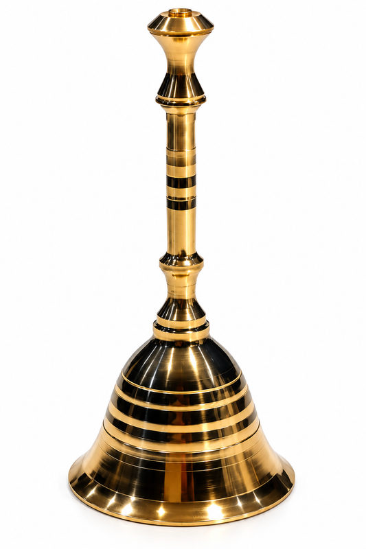 A polished brass bell with a flared base and a slender neck, decorated with horizontal black bands, isolated on a white background for puja.