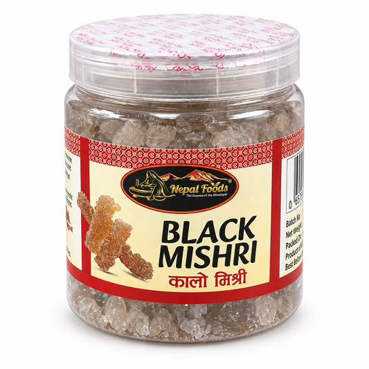 A jar of Nepal Foods Black Mishri (rock sugar) on a white background. The product is packaged in a clear plastic jar with a cream and red label, showing the crystalline sugar inside.