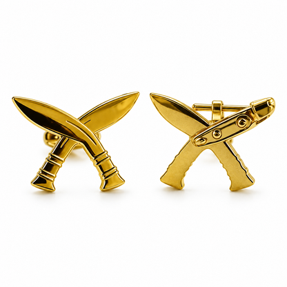 A pair of gold-tone cufflinks shaped like crossed swords, shown on a clean white background with one front-facing and one side-profile view.