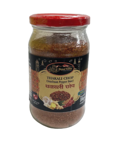 Jar of Thakali Chop spice mix with a red lid on a white background